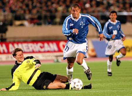 O atacante do Cruzeiro, Donizete (C), é derrubado pelo zagueiro do Borussia Dortmund durante o primeiro tempo da Copa Toyota, o campeonato intercontinental de clubes de futebol, em Tóquio