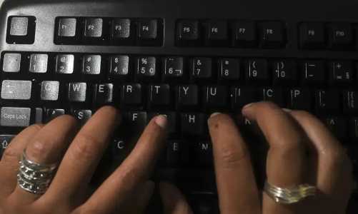 Dedos tocam teclado de computador