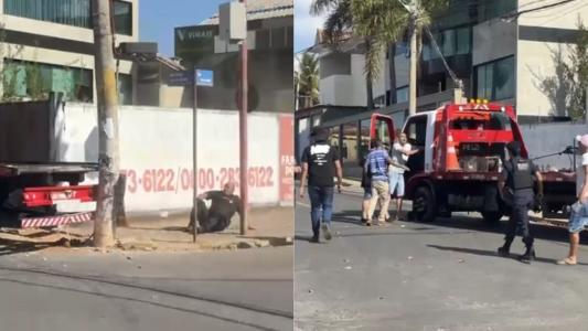 Guarda caído no chão e populares abrindo porta do caminhão