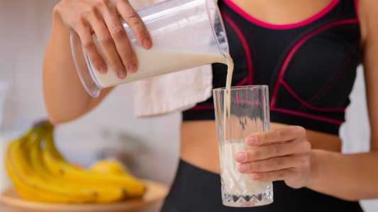 Mulher colocando vitamina no copo