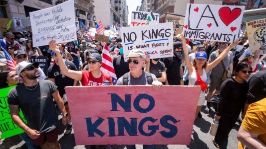 Manifestantes com cartazes "No Kings"