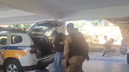 Um dos criminosos sendo levado pela Polícia Militar