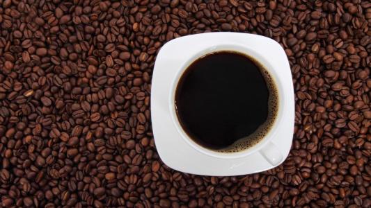 Grãos de café e xícara com café