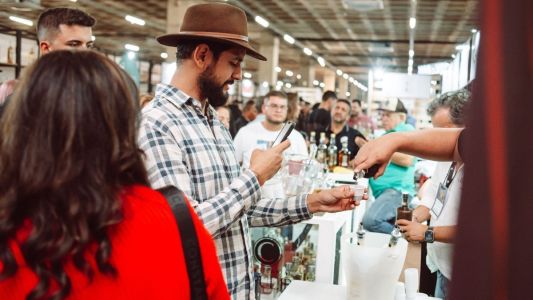 Homem provando cachaça em feira