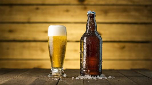 Copo com cerveja e garrafa