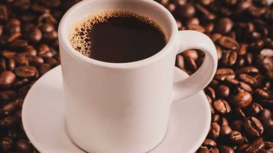 Xícara de café e grãos
