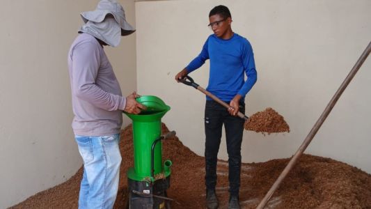 Duas pessoas pegando compostos orgânicos