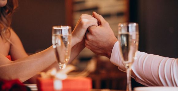 Casal de mão dadas em jantar romântico