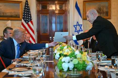 O primeiro-ministro israelense Benjamin Netanyahu (à direita) entrega uma carta ao presidente dos EUA, Donald Trump, durante encontro no Salão Azul da Casa Branca, em Washington.