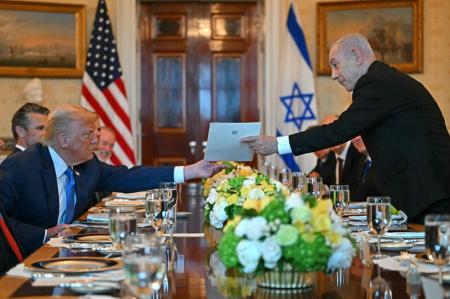 O primeiro-ministro israelense Benjamin Netanyahu (à direita) entrega uma carta ao presidente dos EUA, Donald Trump, durante encontro no Salão Azul da Casa Branca, em Washington.