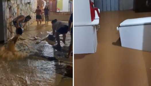 Foto mostra moradores lutando contra a enchente em São José da Lapa