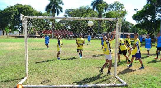 Jovens jogando futebol em campo público na cidade de Montes Claros