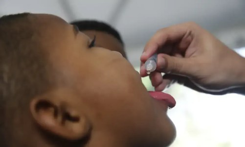 Criança recebendo dose oral de imunização