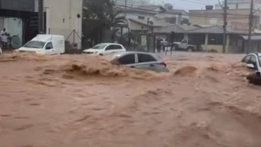 Foto mostra carro sendo levado pela enchente em Itaúna