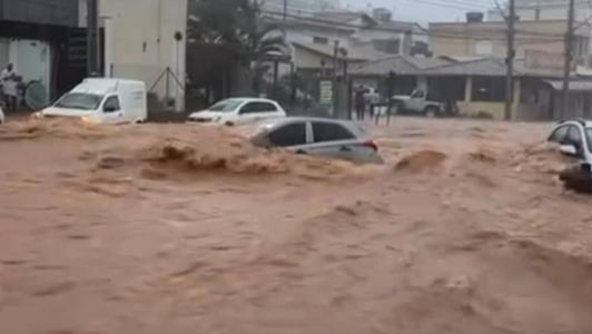 Foto mostra carro sendo levado pela enchente em Itaúna