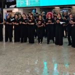 Coral faz 'flash mob' no aeroporto para receber foliões que chegam para o Carnaval em BH