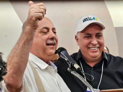 Na imagem, Fuad Noman (esquerda) e Álvaro Damião (direita). Fuad é um homem branco, de bigode branco e usa camisa social branca e suspensório bege. Ao lado dele, Álvaro é um homem branco, usa camisa social preta e boné branco com a logo do partido União Brasil.