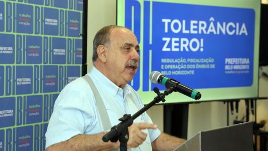 Foto mostra o prefeito de BH, Fuad Noman, em frente a uma televisão escrito 'BH Tolerância Zero'
