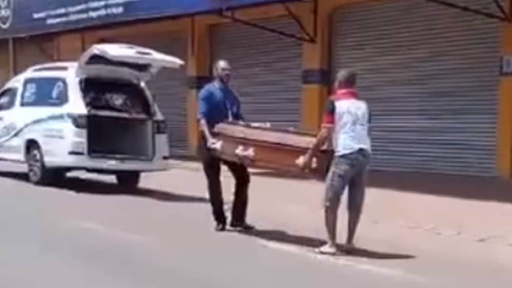 Vídeo: pedestre ajuda funcionário a guardar caixão que caiu de carro funerário