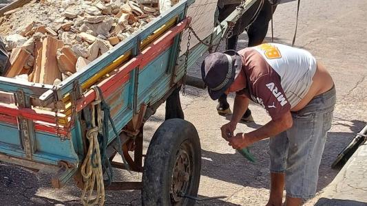Gera arruma o chinelo de dedo enquanto troca do pneu da carroça