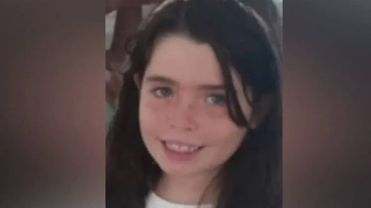 Helena subiu na cadeira para ver as crianças brincando na área comum do prédio