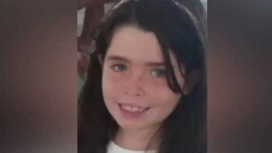 Helena subiu na cadeira para ver as crianças brincando na área comum do prédio
