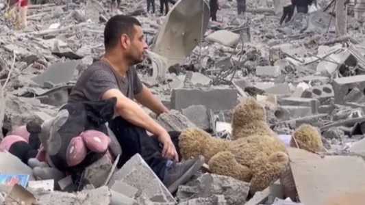 Homem sentado nos destroços de casa em Gaza