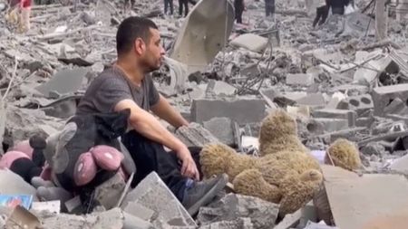 Homem sentado nos destroços de casa em Gaza