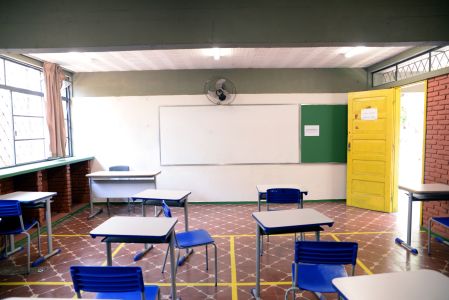 Vista de sala de aula com carteiras e sem alunos em escola de Belo Horizonte
