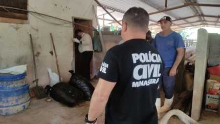 Foto mostra policial civil investigando propriedade na zona rural de Muriaé (MG)