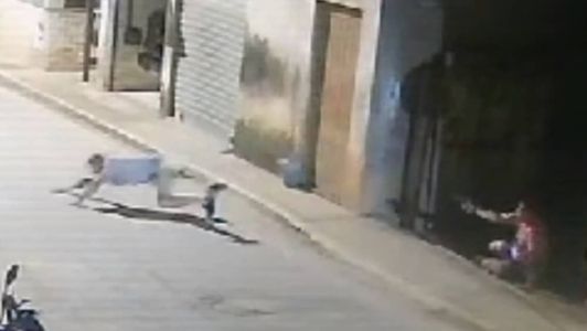 Imagem mostra policial apotando arma para vítima