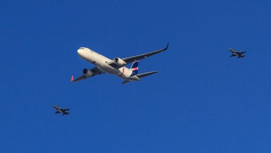 Foto mostra avião comercial sendo acompanhado por duas aeronaves da Força Aérea Brasileira