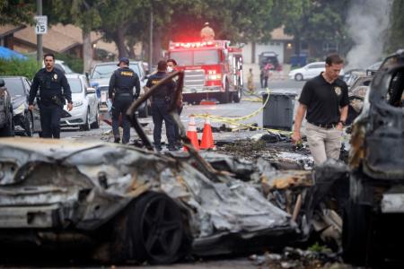 Investigadores examinam o local onde um pequeno avião caiu em uma rua residencial de San Diego, Califórnia, em 22 de maio de 2025.