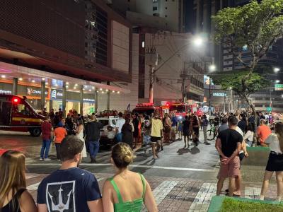 Moradores aguardam ao lado de fora de predio enquanto bombeiros atendem ocorrência de incêndio em juiz de fora