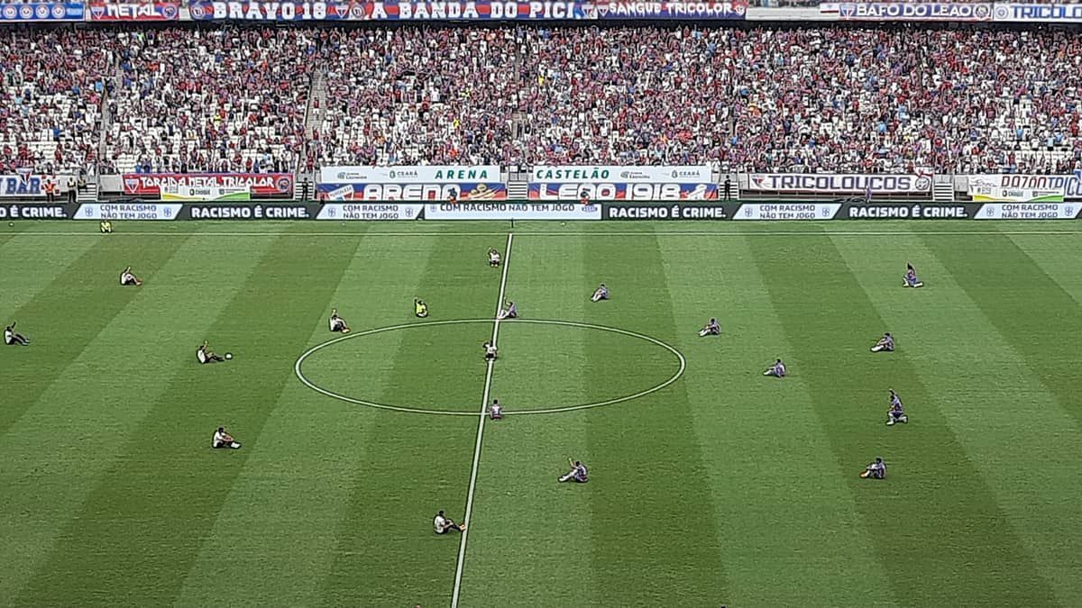Jogadores de Fortaleza e Vasco sentam no gramado em ação antirracista