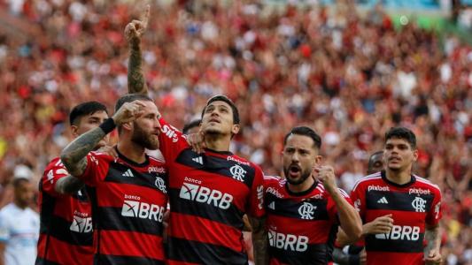 Jogadores do Flamengo comemorando com a torcida rubro-negra ao fundo