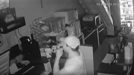 Foto mostra ladrão colocando chiclete na boca enquanto se olha pela tela da câmera de segurança em Governador Valadares (MG)