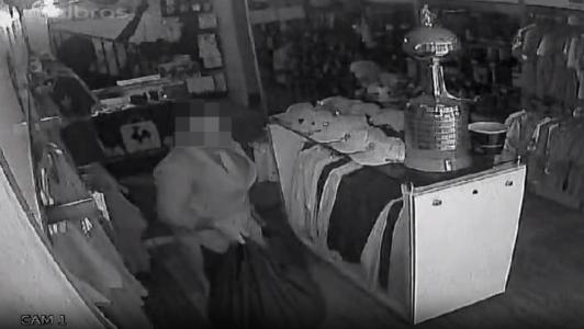 Foto mostra suspeito, de terno e gravata, furtando Loja do Galo no bairro Buritis, em Belo Horizonte