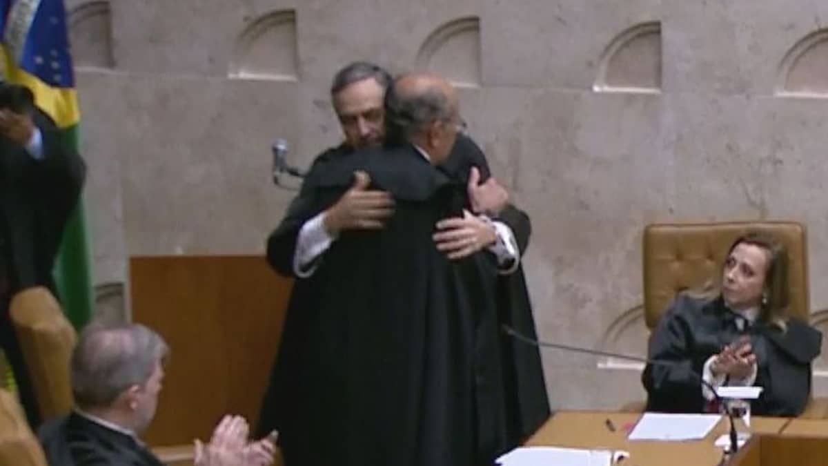 Luís Roberto Barroso abraça Gilmar Mendes durante posse como presidente do STF