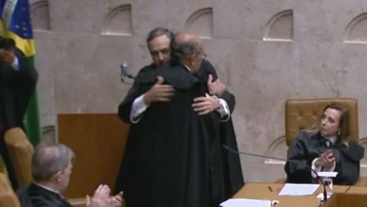 Luís Roberto Barroso abraça Gilmar Mendes durante posse como presidente do STF.