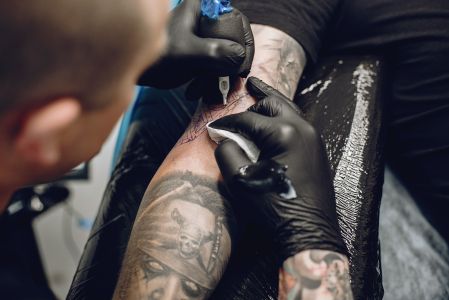 Foto de um tatuador fazendo tatuagem
