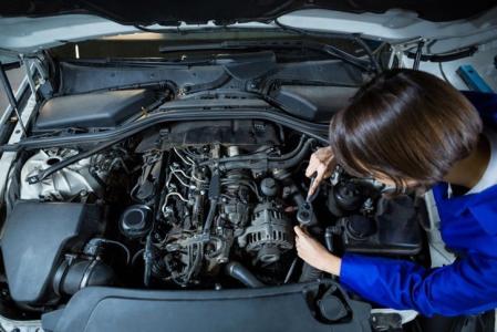 Mecânica em manutenção de motor de carro