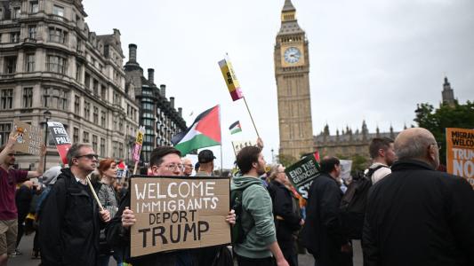 Protesters carry placards and Palestinian flags as they march through Parliament Square with the Houses of Parliament in the background in London on September 17, 2025 during a national march organised by the Stop Trump Coalition against the State Visit of US President Donald Trump. US President Donald Trump arrived in Britain for an unprecedented second State Visit, with the UK government rolling out a royal red carpet welcome to win over the mercurial leader. (Photo by JUSTIN TALLIS / AFP)