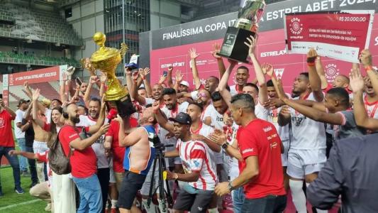 Momento em que o Estrela Mirim levanta a taça da Copa Itatiaia Estrela Bet