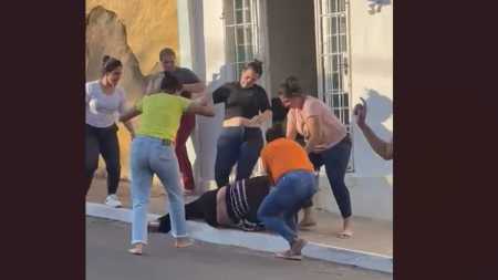 Momento em que o grupo de mães joga a fisioterapeuta no chão e a atinge com socos e pontapés