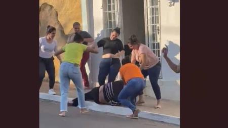Momento em que o grupo de mães joga a fisioterapeuta no chão e a atinge com socos e pontapés