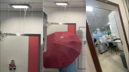 Profissonal do hospital utiliza guarda-chuva para escapar dos vazamentos
