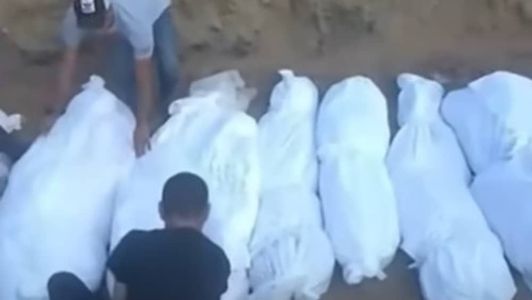 Moradores de Gaza enterram corpos em vala comunitária