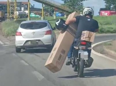 Motociclista se arrisca para transportar caixa no Anel Rodoviário de BH