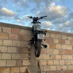 Moto fica pendurada em muro do pátio do Detran após adolescentes tentarem roubá-la em Corinto